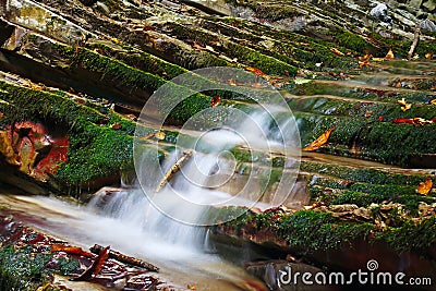 Rocks covered with moss with flowing streams of the mountain creek Stock Photo