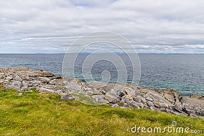 Rocks, grass and beach in Inisheer Island Stock Photo
