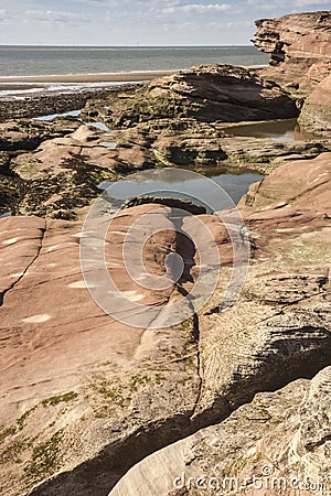 Rocks, pools and cliff at Hilbre Island, Wirral, England Stock Photo