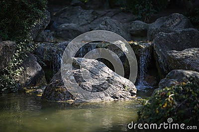 Rocks in a creek in front of a waterfall. Stock Photo