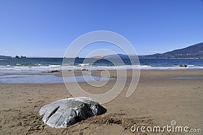 Rocks rise up the sand on the beach Stock Photo