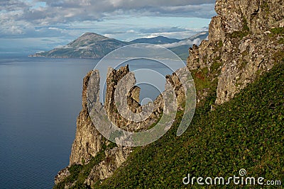 Rocks on a steep slope above the sea. Stock Photo