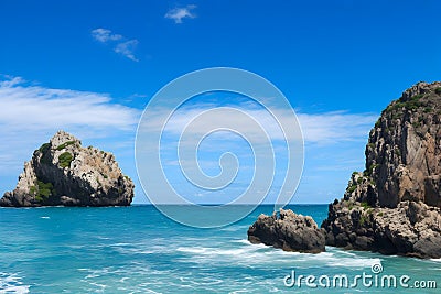 A rocky beach with blue water and blue sky Generated Ai Stock Photo