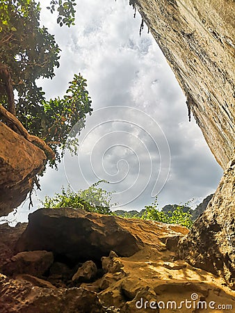 Rocky cliff with sunlight coming through, a cave with rocks and stones Stock Photo