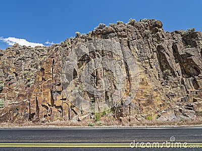 Rocky cliffs abut State Highway 225 north of Elko, Nevada, USA Stock Photo
