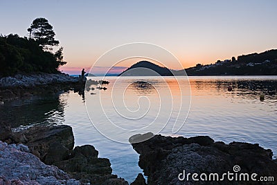 Rocky coast and calm water of Panormos bay after sunset, Skopelos island Editorial Stock Photo