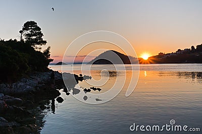 Rocky coast and calm water of Panormos bay at sunset, Skopelos island Stock Photo