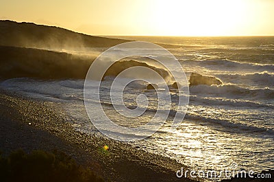 The rocky coast of Cyprus at sunset. Caves and cliffs. Waves at sea. Coral seacoast. Stock Photo