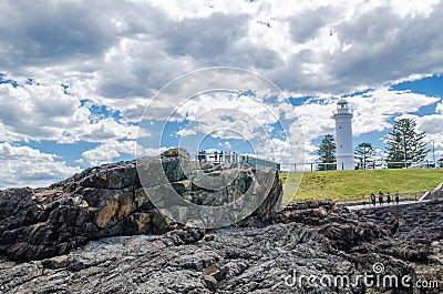 Rocky coastal views with iconic lighthouse at Blowhole Point, south of Kiama Harbour, in cloudy sky day. Editorial Stock Photo