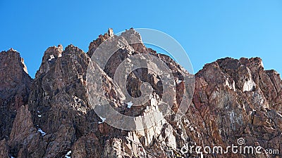 Rocky mountain top. You can see little people. Climbers climb to the top. Stock Photo