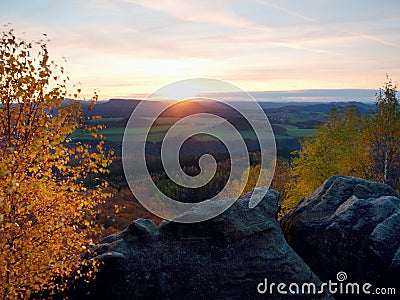 Rocky mountain with view into evening autumnal valley. Stock Photo