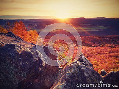 Rocky mountain with view into evening autumnal valley. Stock Photo