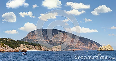 Rocky seashore, resort, beach. The mountains, trees, shrubs, holidaymakers sail catamarans and kayaks. Photo. Stock Photo