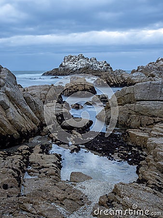 Rocky Shore of the California Coast, Overcast Evening Sky Stock Photo