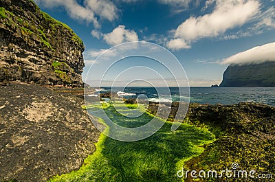 Rocky shore with small sea ponds near village Mikladalur, Kalsoy island, Faroe Islands Stock Photo