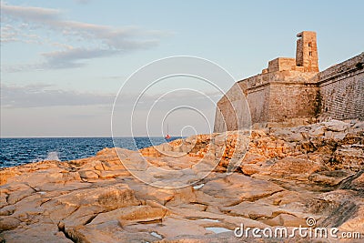 Rocky shore of Valleta with city walls and beautiful landscape. Coastline of Malta Stock Photo