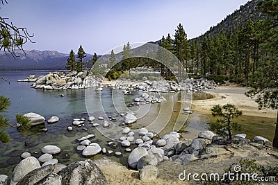 Rocky shoreline of Lake Tahoe and surrounding mountains Stock Photo