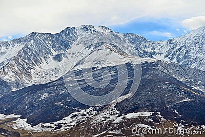 Rocky snow-capped mountains over the village of Fiagdon Stock Photo