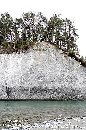 Rocky wall with coniferous trees above water level of Anterior Rhine river in Ruinaulta ravine in Switherland. Stock Photo