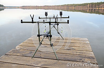 Rod pod with electronic bite alarms on pier by lake Stock Photo