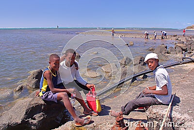 RODRIGUES ISLAND, MAURITIUS - NOVEMBER 13, 2012: Octopus fishing with three local boys posing Editorial Stock Photo