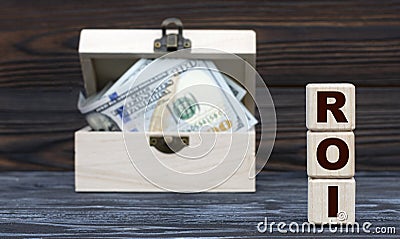 ROI - acronym on cubes against the background of a chest of money Stock Photo