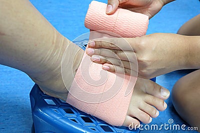 Roll a bandage for protect foot. Wrap foot bandage Stock Photo