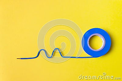 Roll of blue plastic duct tape and piece of electrical wire on yellow background. Close up. Connection concept Stock Photo