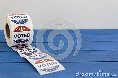 Roll of I Voted Today stickers on blue wooden table with copy space. US presidential election concept Editorial Stock Photo