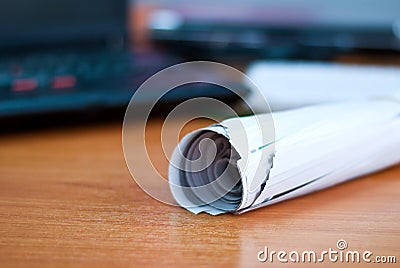 Roll of newspaper on workspace Stock Photo