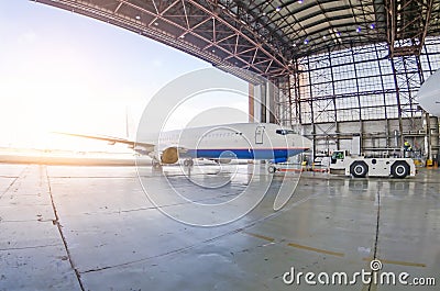 Roll-out of the aircraft from the hangar by a aerodrome tractor, after repair. Stock Photo