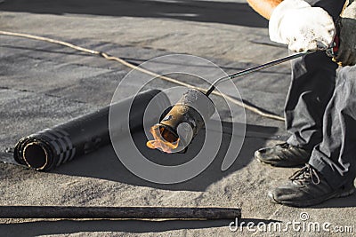 Roll roofing Installation with propane blowtorch during construction works Stock Photo