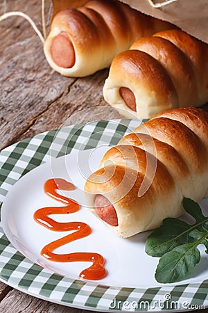 Roll with sausage on a plate with ketchup and arugula vertical Stock Photo