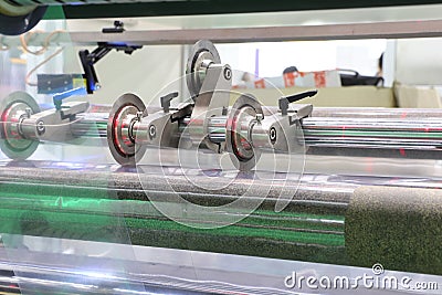 Roll slitting machine ; a shearing operation that cuts a large roll of material into narrower rolls Stock Photo