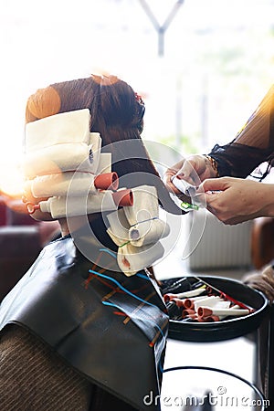 Roll some hair with the rod perming Stock Photo