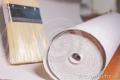 A roll of white textured wallpaper is ready for apartment renovation. DIY repair Stock Photo