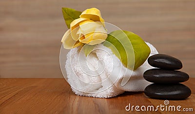 Roll of white towels on table, yellow flower - with copy space Stock Photo