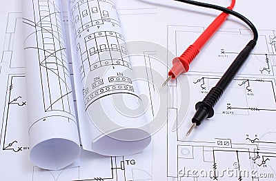 Rolled electrical diagrams and cables of multimeter on drawing of house Stock Photo