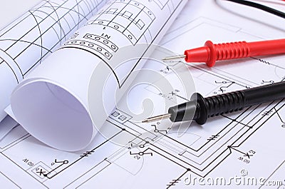 Rolled electrical diagrams and cables of multimeter on drawing of house Stock Photo
