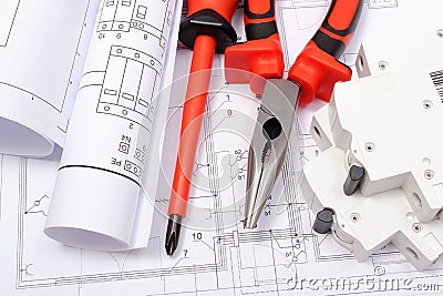 Rolled electrical diagrams, electric fuse and work tools on construction drawing of house Stock Photo