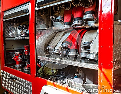 Rolled fire hoses, arranged in rows, in the glove compartment of the fire truck. Stock Photo