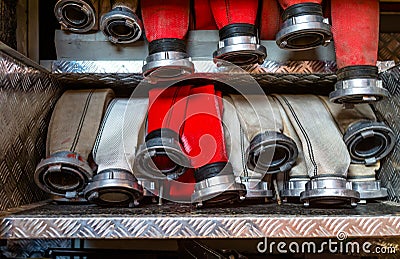 Rolled fire hoses, arranged in rows, in the glove compartment of the fire truck. Stock Photo