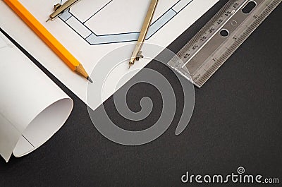 Rolled house diagrams and accessories for drawing lying on construction drawing Stock Photo