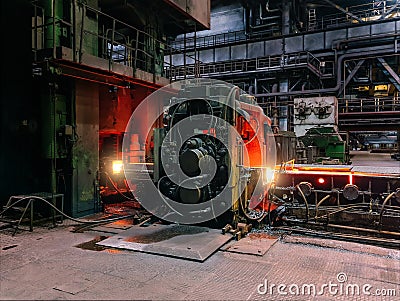 Rolled metal factory. Hot steel bar on conveyor moving through rollers Stock Photo