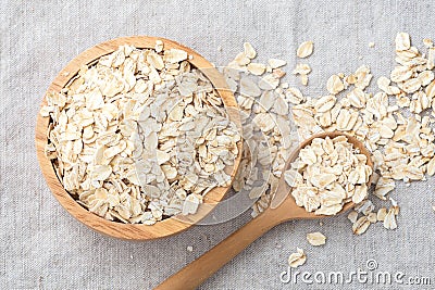 Rolled oat, raw oatmeal with spoon in wooden bowl Stock Photo
