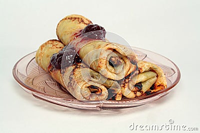 Rolled pancakes with strawberry jam on a glass plate Stock Photo