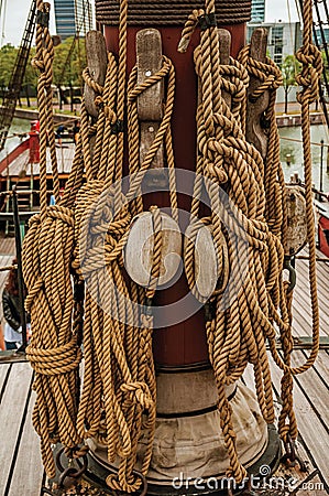 Rolled rope and pulleys supported on the central mast of a sailing ship on a cloudy day in Amsterdam. Stock Photo