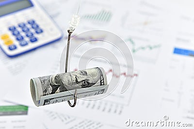 Rolled up scroll of US 100 dollar bill on a fishing hook. Stock Photo