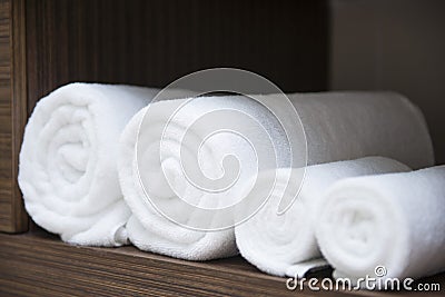 Rolled white towels on shelf Stock Photo