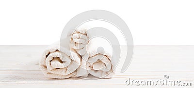 Rolled white towels on white wooden table on white background. Copy space and top view. Bathroom objects for shower body Stock Photo